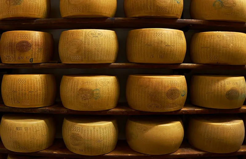 Forme di Parmigiano Reggiano sulle scalere di legno in un magazzino di stagionatura